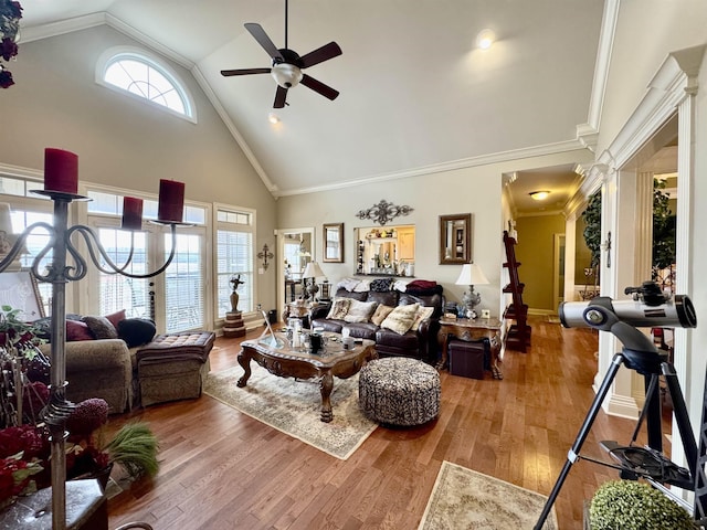 living room featuring ceiling fan, wood-type flooring, high vaulted ceiling, and ornate columns