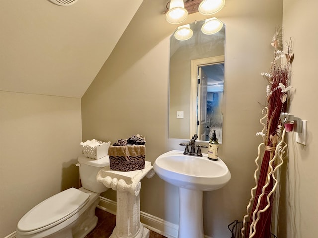 bathroom with lofted ceiling and toilet