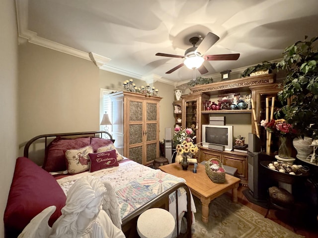 bedroom featuring ceiling fan, crown molding, and hardwood / wood-style flooring