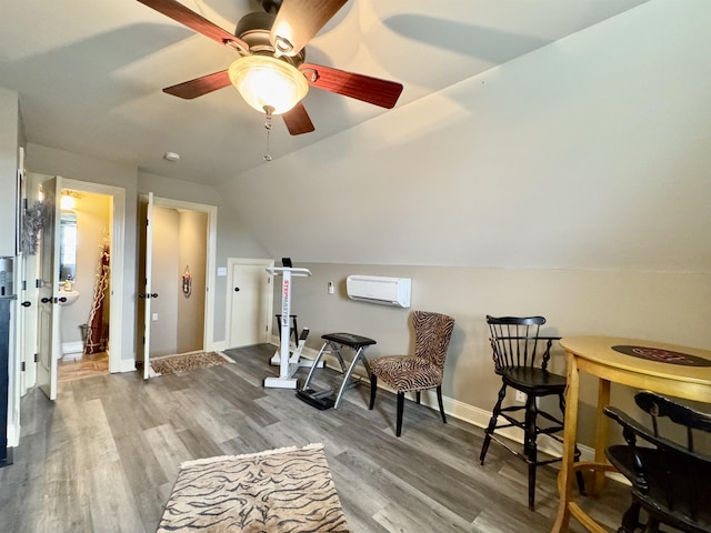 sitting room featuring hardwood / wood-style flooring, vaulted ceiling, ceiling fan, and an AC wall unit