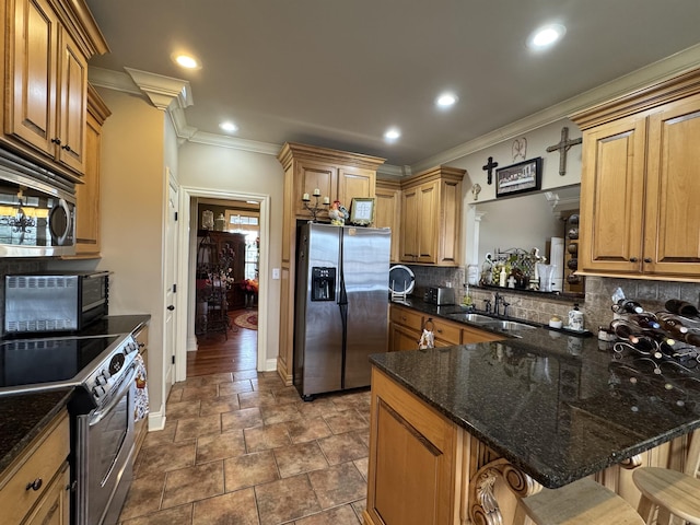 kitchen with sink, stainless steel appliances, a kitchen breakfast bar, kitchen peninsula, and dark stone counters