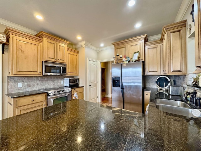 kitchen with tasteful backsplash, sink, light brown cabinetry, and appliances with stainless steel finishes