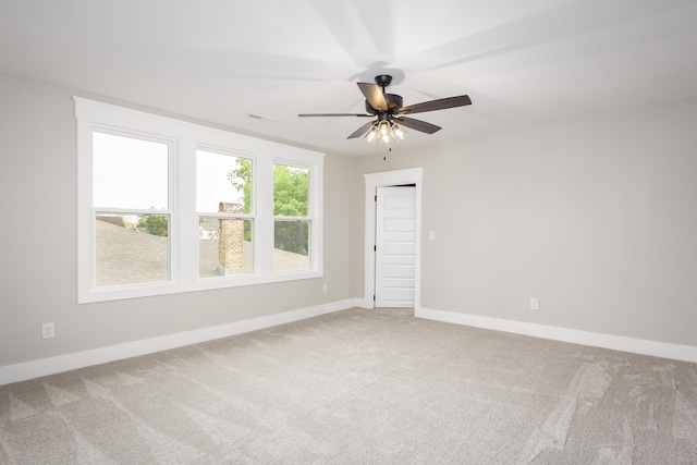 unfurnished room featuring carpet flooring, baseboards, visible vents, and ceiling fan