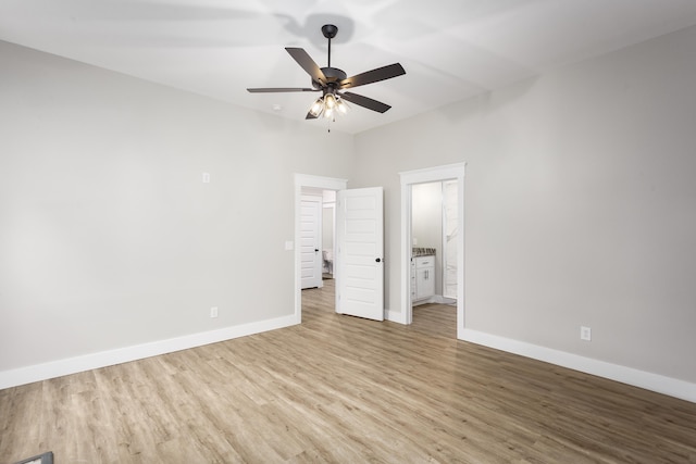 unfurnished bedroom with baseboards, ceiling fan, wood finished floors, and ensuite bath