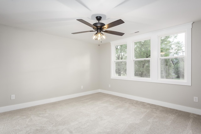 spare room with a ceiling fan, baseboards, visible vents, and carpet
