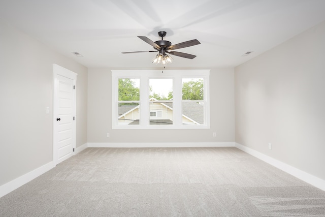 carpeted empty room featuring baseboards, ceiling fan, and visible vents