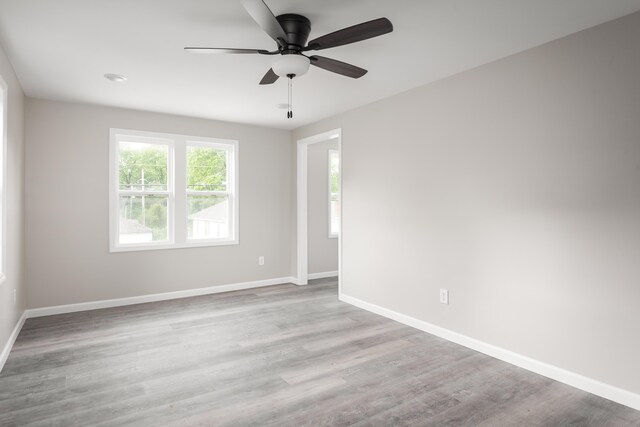 unfurnished room with baseboards, ceiling fan, and wood finished floors