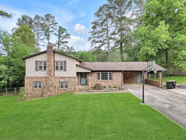 - split level home featuring brick siding, driveway, a carport, and a chimney