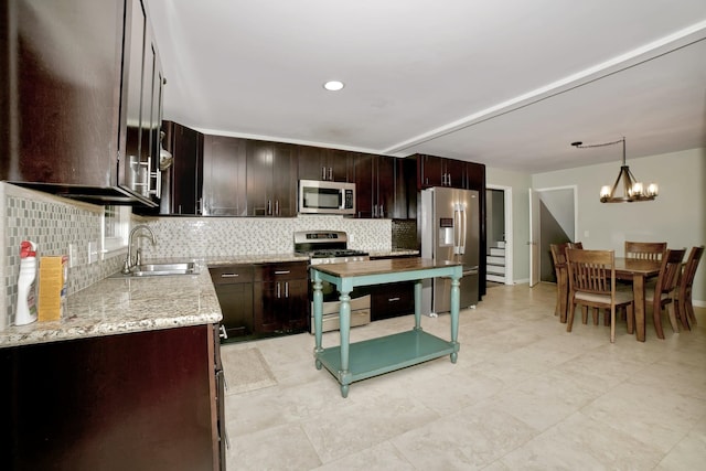  - kitchen with stainless steel appliances, a sink, tasteful backsplash, dark brown cabinets, and hanging light fixtures