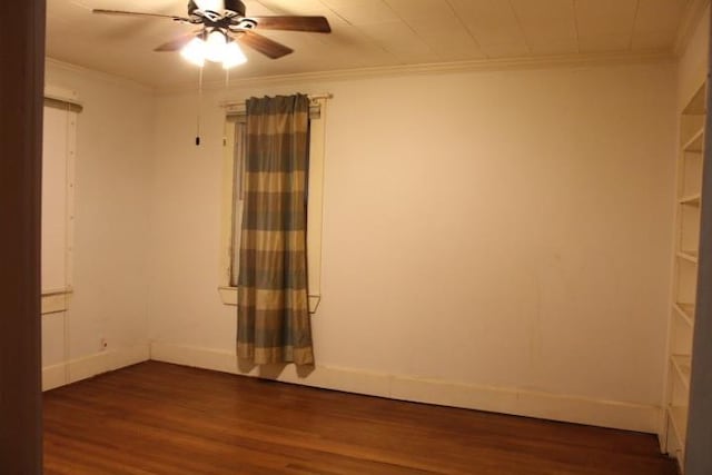 empty room with ceiling fan, crown molding, and dark wood-type flooring