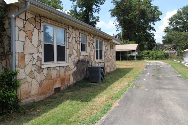 view of side of property with a yard and cooling unit