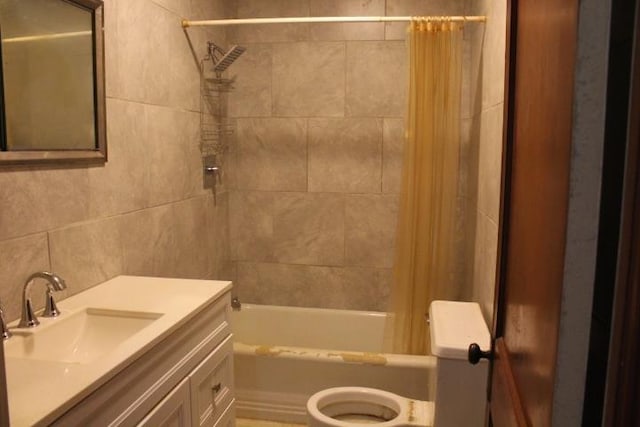 full bathroom with vanity, toilet, tile walls, and shower / tub combo with curtain