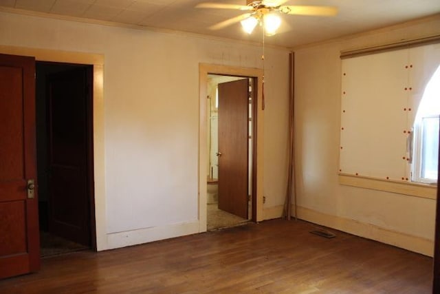 empty room with ceiling fan, dark hardwood / wood-style flooring, and crown molding