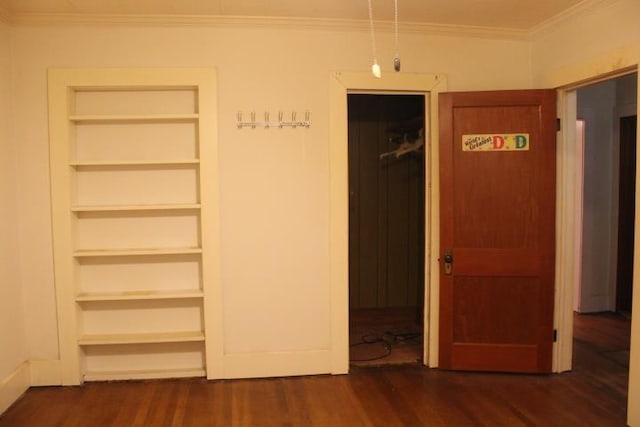 unfurnished bedroom with crown molding and dark wood-type flooring