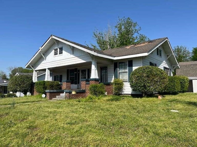 view of front of property with covered porch and a front lawn