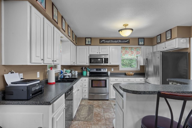 kitchen featuring a breakfast bar area, sink, white cabinets, and stainless steel appliances