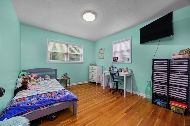 bedroom featuring light wood-type flooring and a textured ceiling