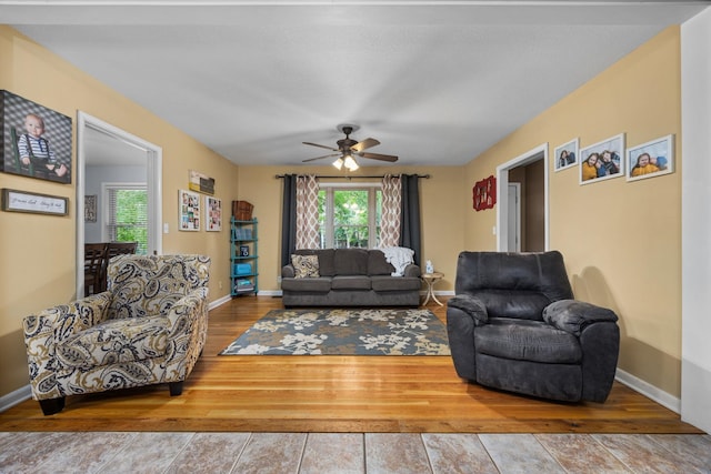 living room with wood-type flooring and ceiling fan