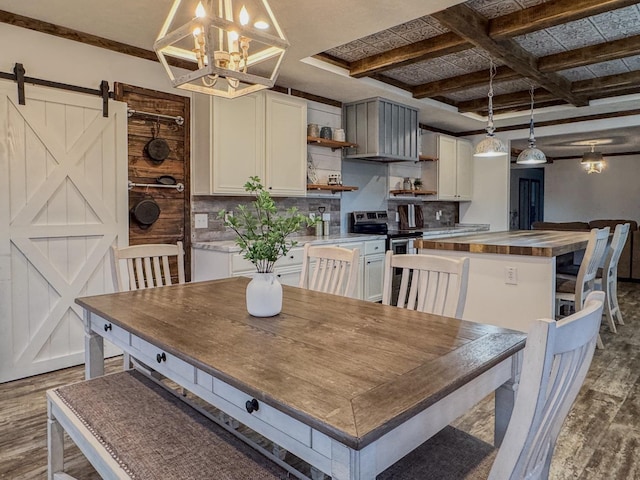 dining room with coffered ceiling, dark hardwood / wood-style floors, a chandelier, and a barn door