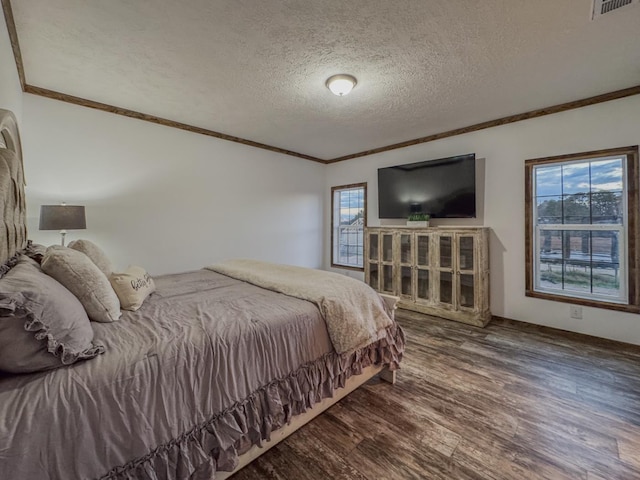 bedroom with crown molding, wood-type flooring, multiple windows, and a textured ceiling