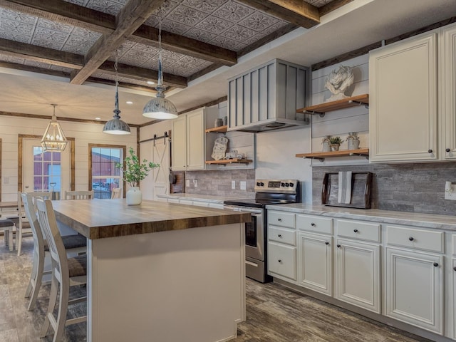 kitchen featuring electric stove, butcher block counters, hanging light fixtures, dark hardwood / wood-style floors, and a center island