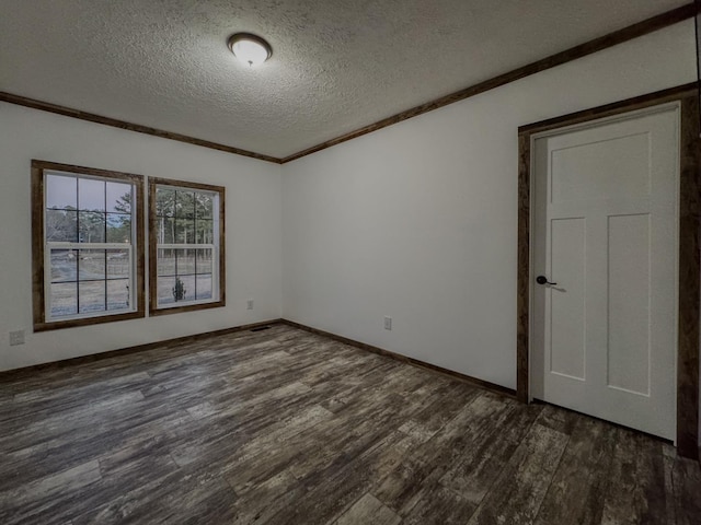 empty room with dark wood-type flooring, ornamental molding, and a textured ceiling