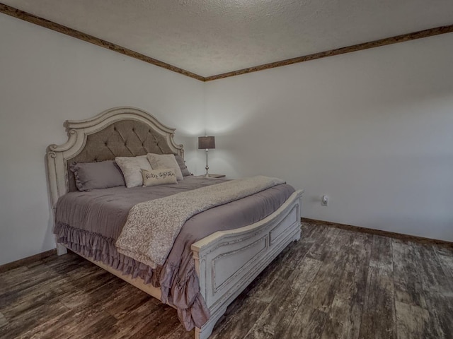 bedroom featuring crown molding, dark hardwood / wood-style flooring, and a textured ceiling