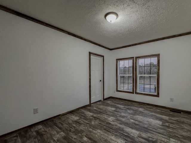 empty room featuring dark hardwood / wood-style flooring, crown molding, and a textured ceiling