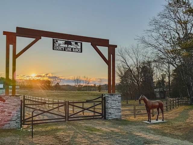 gate at dusk with a yard and a rural view