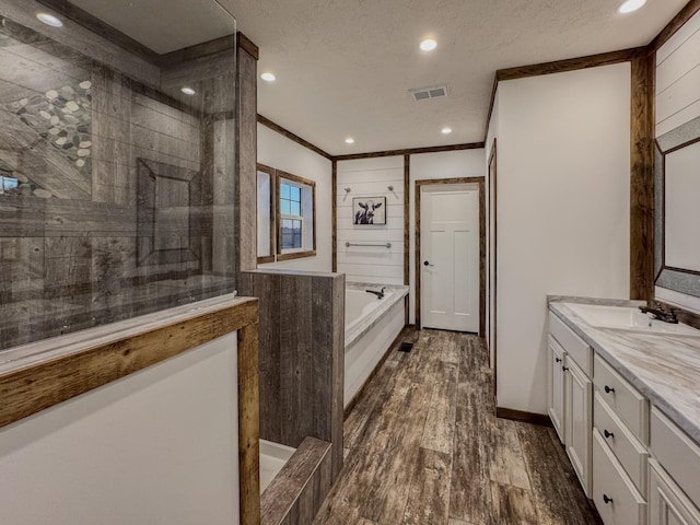 bathroom with vanity, wood-type flooring, a textured ceiling, and separate shower and tub