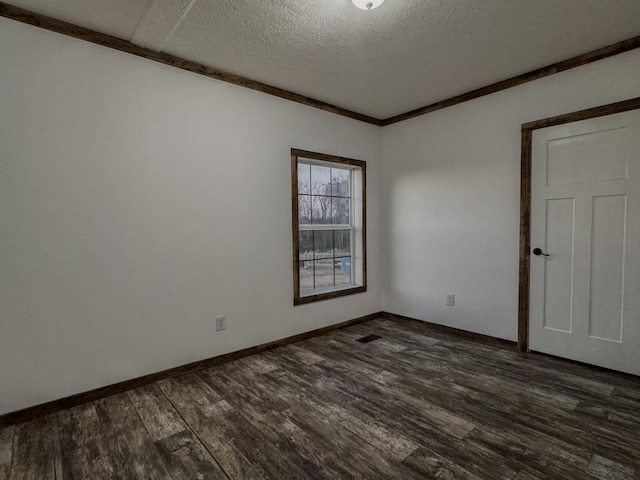 unfurnished room featuring dark wood-type flooring and a textured ceiling