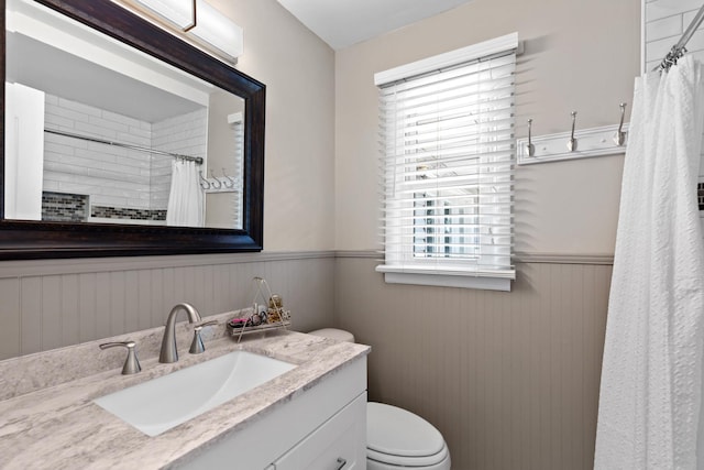 bathroom featuring a shower with shower curtain, vanity, a healthy amount of sunlight, and toilet