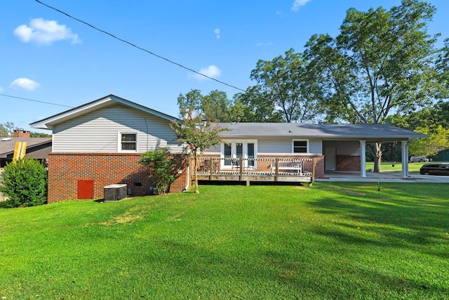 back of house with central air condition unit, a deck, and a lawn