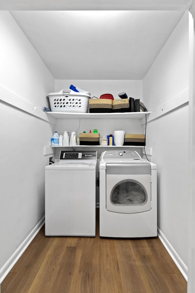 clothes washing area featuring dark hardwood / wood-style flooring and washer and dryer