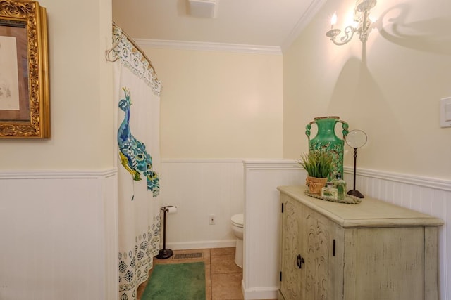 bathroom with tile patterned floors, toilet, and crown molding