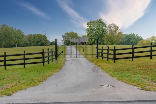 view of gate featuring a yard and a rural view