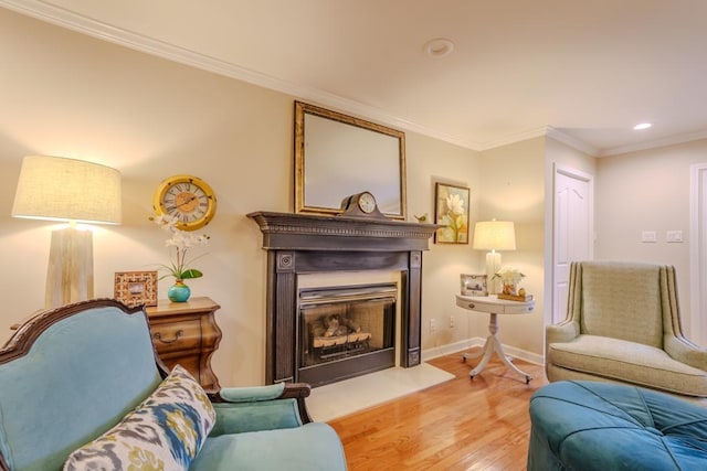 living area with crown molding and light hardwood / wood-style flooring