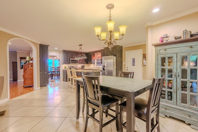 tiled dining room featuring crown molding and an inviting chandelier