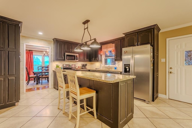 kitchen featuring a center island, crown molding, appliances with stainless steel finishes, decorative light fixtures, and dark brown cabinets