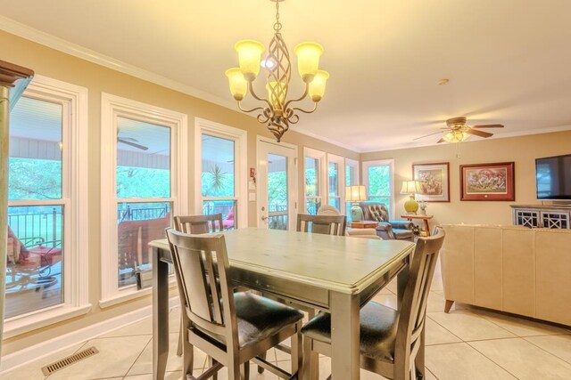 tiled dining space featuring crown molding, a healthy amount of sunlight, and ceiling fan with notable chandelier