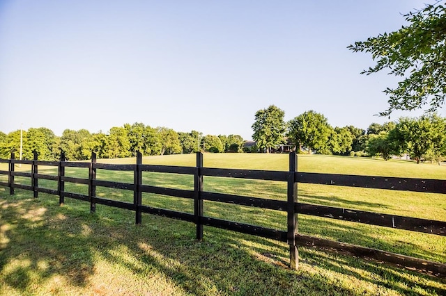 view of gate featuring a lawn and a rural view