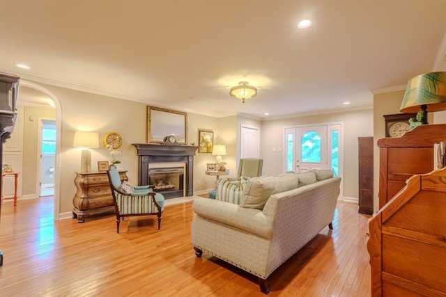 living room featuring light wood-type flooring and ornamental molding