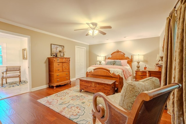 bedroom with ceiling fan, a closet, wood-type flooring, and ornamental molding