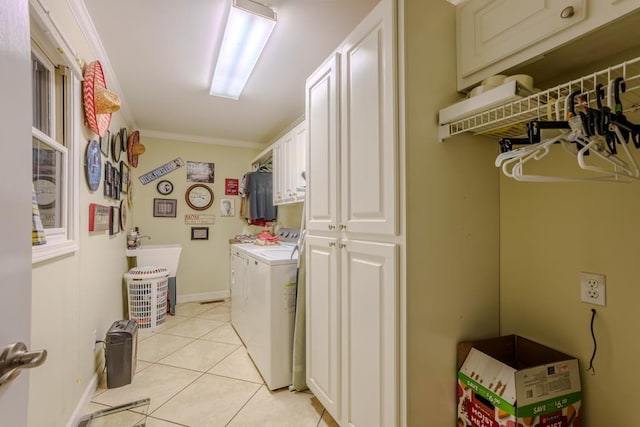 clothes washing area with cabinets, light tile patterned floors, crown molding, and separate washer and dryer