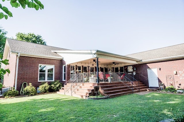 rear view of property featuring a lawn, ceiling fan, and a porch