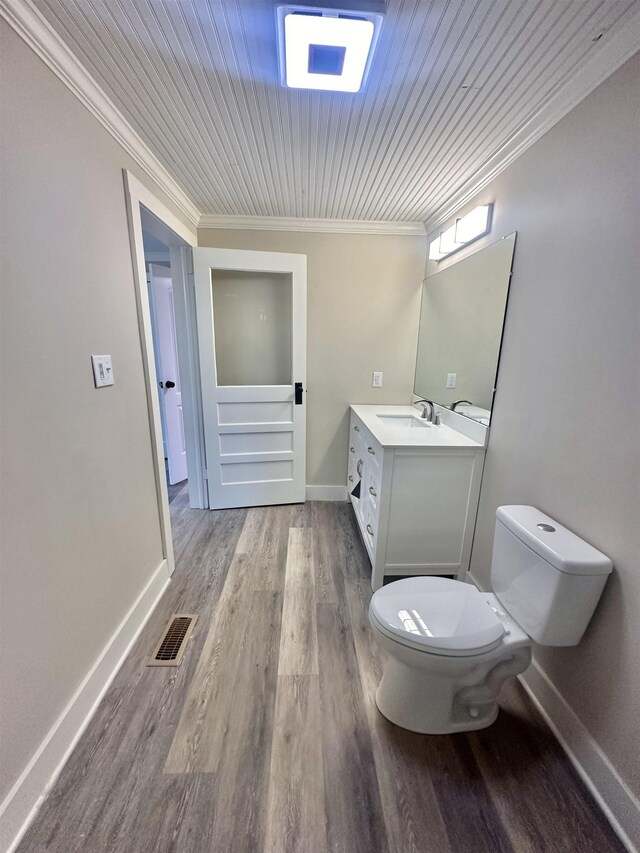 bathroom with vanity, hardwood / wood-style flooring, toilet, and crown molding