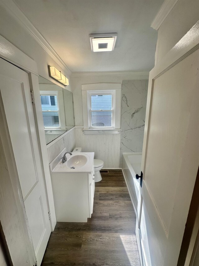 bathroom with wood-type flooring, vanity, toilet, and ornamental molding