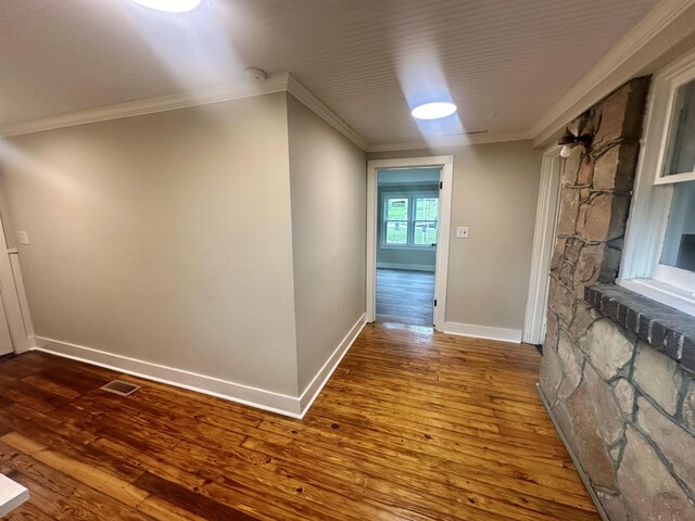 hallway with hardwood / wood-style floors and ornamental molding