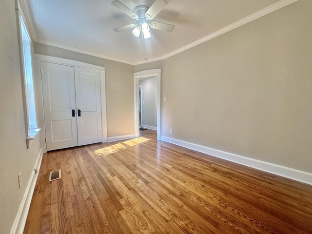 unfurnished bedroom featuring a closet, ceiling fan, crown molding, and light wood-type flooring