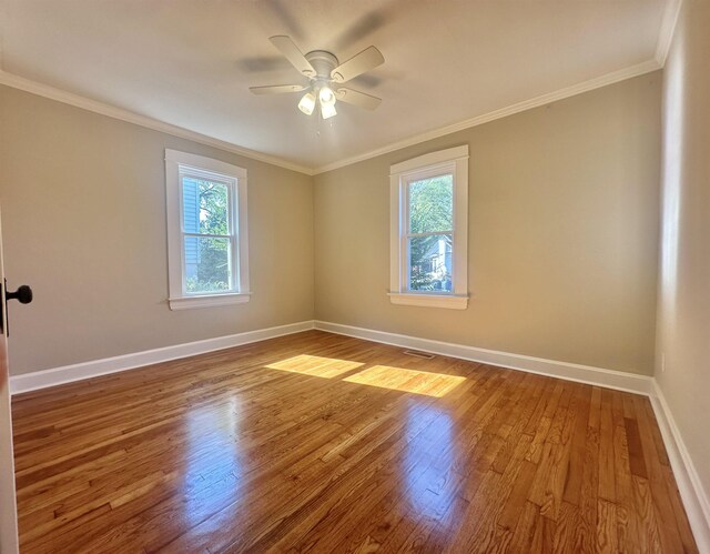 unfurnished room featuring crown molding, plenty of natural light, ceiling fan, and hardwood / wood-style flooring